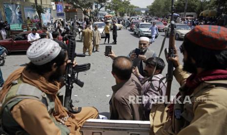 Warga Afghanistan berfoto selfie dengan pejuang Taliban saat berpatroli di kota Kabul, Afghanistan, Kamis, 19 Agustus 2021. Taliban merayakan Hari Kemerdekaan Afghanistan pada hari Kamis dengan menyatakan mereka mengalahkan Amerika Serikat.