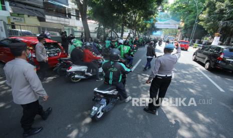 Polisi membubarkan kerumunan ojol saat aski menolak Pemberlakuan Pembatasan Kegiatan Masyarakat (PPKM) oleh massa gabungan pelajar, mahasiswa, pedagang dan ojol di Kawasan Balai Kota, Jalan Wastukancana, Kota Bandung, Rabu (21/7). Mereka berharap pemerintah segera menghentikan PPKM, karena kebijakan tersebut dianggap telah menyengsarakan rakyat.