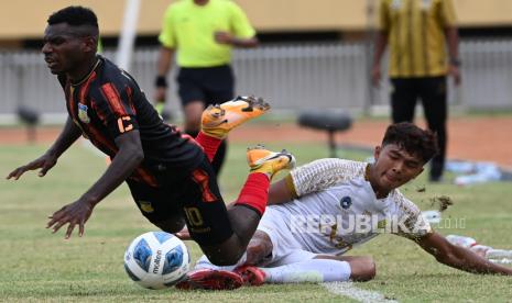 Pesepak bola Aceh M Fayrushi (kanan) berebut bola dengan pesepak bola Papua Ricky Ricardo Cawor (kiri) saat pertandingan babak enam besar Sepak Bola putra PON Papua di Stadion Mandala, Kota Jayapura, Papua, Rabu (6/10/2021). Tim sepak bola Papua menang atas tim Aceh dengan skor akhir 1-0.