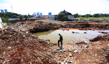 Warga melintas diarea lahan  Pembangunan waduk Lebak Bulus, di Jakarta,Jumat (7/1/2022).  Pengerjaan waduk yang digunakan sebagai salah satu solusi penanganan banir di Jakarta dan  luas waduk Lebak Bulus diperkirakan mencapai 3-4 hektare yang secara khusus untuk menampung debit air lebih banyak di wilayah itu.  