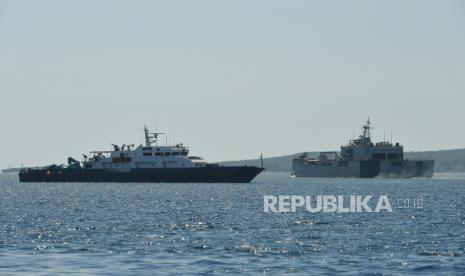 KRI Teluk Banten-516 melintasi di dekat kapal patroli Polairud Baharkam Polri ketika berlayar untuk melakukan operasi pencarian KRI Nanggala-402 di Pelabuhan Tanjung Wangi, Banyuwangi, Jawa Timur, Ahad (25/4/2021). TNI AL menaikan status operasi pencarian kapal selam KRI Nanggala-402 yang hilang di perairan utara Pulau Bali, dari tahap hilang kontak atau sub-missed ke tahap tenggelam atau sub-sunk dan pencarian akan terus dilakukan hingga seluruh awak kapal selam KRI Nanggala-402 dapat dievakuasi. 