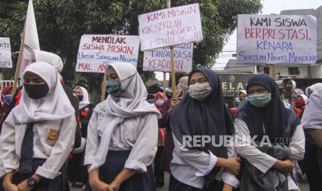 Sejumlah siswa bersama orang tuanya berunjuk rasa di depan Sekolah SMA Negeri 1, Depok, Jawa Barat, Senin (13/7/2020). Unjuk rasa tersebut digelar sebagai bentuk protes kepada Dinas Pendidikan Provinsi Jawa Barat yang belum mengakomodir siswa miskin untuk dapat menuntut ilmu di tingkat Sekolah Menengah Atas (SMA) Negeri di Kota Depok. 