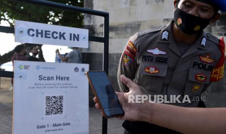 Wisatawan memindai QR Code dengan aplikasi PeduliLindungi sebelum memasuki kawasan wisata Pantai Kuta, Badung, Bali, Ahad (26/9/2021). Pengelola Daya Tarik Wisata (DTW) Pantai Kuta mulai memberlakukan penerapan aplikasi PeduliLindungi bagi seluruh wisatawan untuk mewujudkan aktivitas pariwisata yang aman selama masa pandemi COVID-19. 