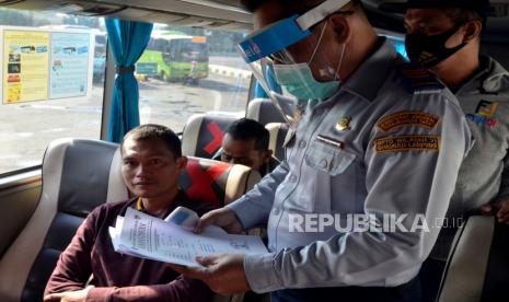 Petugas melakukan pemeriksaan berkas kepada calon penumpang yang akan melakukan perjalanan menggunakan armada bus di Terminal Induk Rajabasa Bandar Lampung, Lampung, Kamis (11/6/2020). Terminal Induk Rajabasa mulai melayani perjalanan rute Antar Kota Antar Provinsi (AKAP) dan Antar Kota Dalam Provinsi (AKDP) dengan penerapan tatanan normal baru dan persyaratan protokol kesehatan