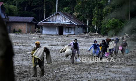 Warga mengangkat barang miliknya melewati material lumpur di Desa Radda, Kabupaten Luwu Utara, Sulawesi Selatan, Sabtu (18/7/2020). Pascabanjir bandang sejumlah warga yang terdampak mulai mengambil barangnya yang masih bisa digunakan. 