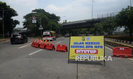 Kendaraan melintas disamping papan informasi penutupan jalan di Sekitar Kawasan gedung DPR, Senayan, Jakarta. Polda Metro Jaya siapkan rekayasa lalu lintas bersifat situasional hadapi unjuk rasa. Ilustrasi. 