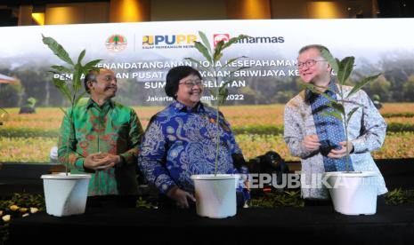 Menteri Lingkungan Hidup dan Kehutanan (LHK) Siti Nurbaya Bakar (tengah) bersama Board Member Sinar Mas Franky O Widjaja (kanan) dan Sekjen Kementerian LHK Bambang Hendroyono (kiri) memasukan bibit pohon ke dalam pot usai penandatanganan nota kesepahaman (MoU) pembangunan Pusat Persemaian Sriwijaya Kemampo di Jakarta, Selasa (6/9/2022). Kementerian LHK dan Kementerian PUPR Bersama Sinar Mas membangun Pusat Persemaian Sriwijaya Kemampo di Kabupaten Banyuasin, Sumatera Selatan, seluas enam hektare berkapasitas 10 juta bibit per tahun untuk mendukung program pemerintah dalam pemulihan ekosistem melalui rehabilitasi hutan dan lahan. Foto: Tahta Aidilla/Republika