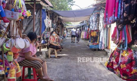 Seorang wanita menunggu pelanggan di luar tokonya di Sanur, Bali, Indonesia, 09 Juni 2021. Angka kunjungan wisatawan mancengara (wisman) selama tahun 2021 hanya mencapai 1.557.530 kunjungan.