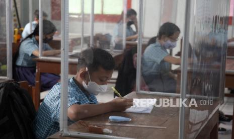 Siswa SD Warga Solo menyalin materi dari guru saat hari pertama Pembelajaran Tatap Muka (PTM) di Solo, Jawa Tengah, Kamis (2/9/2021). Pemerintah Kota Solo mulai mengizinkan pelaksanaan PTM secara terbatas dengan menerapkan protokol kesehatan guna mencegah penyebaran COVID-19. 