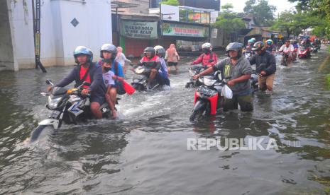 Sejumlah pengendara melintasi jalan yang tergenang banjir di Desa Tanjung Karang, Jati, Kudus, Jawa Tengah, Selasa (19/3/2024). Jalan provinsi penghubung Kabupaten Kudus-Purwodadi tersebut terendam banjir dengan ketinggian mencapai 70 centimeter sejak Kamis (14/3/2024) atau enam hari terakhir akibat intensitas hujan tinggi serta limpasan Sungai Wulan. 