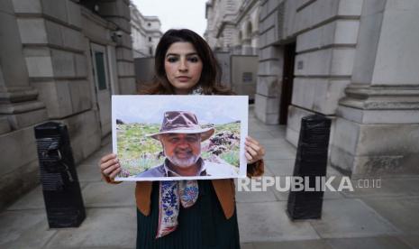 Roxanne Tahbaz memegang potret ayahnya, Morad Tahbaz yang ditahan di Iran saat unjuk rasa di London, Inggris, 13 April 2022. 