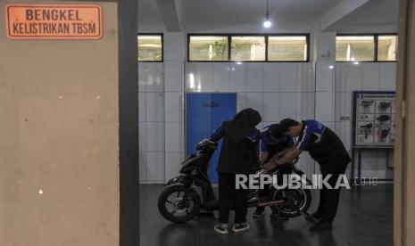 Siswa SMK memeriksa komponen sepeda motor berbahan bakar minyak yang telah dikonversikan ke listrik di Bengkel Kelistrikan TBSM SMKN 8 Kota Bandung, Jalan Kliningan, Lengkong, Kota Bandung, Provinsi Jawa Barat, Selasa (14/2/2023). Siswa kelas XI dan XII jurusan Teknik Bisnis Sepeda Motor (TBSM) mengkonversikan motor berbahan bakar minyak ke tenaga listrik yang diberi nama Matric 8 (Matic Electric). Sepeda motor listrik tersebut memiliki daya 72 volt dan mampu menempuh jarak 50 kilometer hingga 60 kilometer dengan pengisian daya selama lima jam.