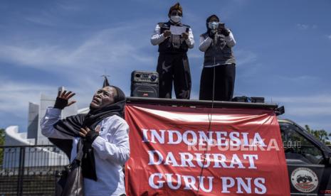 Sejumlah guru dari berbagai forum guru melakukan aksi Indonesia Darurat Guru PNS di kawasan Monumen Perjuangan Rakyat Jawa Barat (Monpera), Kota Bandung, Kamis (25/11). Dalam aksi yang bertepatan dengan peringatan Hari Guru Nasional 2021 tersebut menuntut agar guru yang masih berstatus honorer bisa diangkat menjadi PNS atau Pegawai Pemerintah dengan Perjanjian Kerja (PPPK). Hal tersebut dikarenakan Indonesia masih kekurangan 1,3 juta guru di sekolah negeri. Foto: Republika/Abdan Syakura