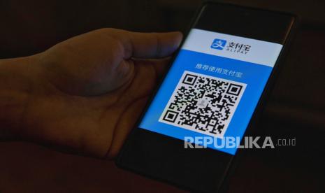 Seseorang yang memegang smartphone menunjukkan kode QR Alipay untuk pembayaran di Shanghai, Cina, 06 Januari 2021. Bank sentral China (PBOC) berjanji akan memperketat pengawasan aktivitas keuangan di platform pembayaran online.