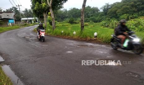 Pengendara menghindari jalan berlubang di Jalan Nyangkringan, Banyurejo, Sleman, Yogyakarta.