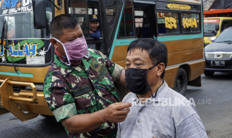 Prajurit TNI Koramil 10 Wiradesa membagikan masker di jalur Pantura Wiradesa, Kabupaten Pekalongan, Jawa Tengah, Rabu (15/4). Panglima TNI Marsekal Hadi Tjahjanto mengajukan penambahan anggaran sebesar Rp 3,2 triliun, untuk penanganan virus Covid-19 atau corona. 