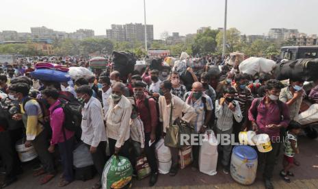 Orang-orang yang memakai masker sebagai tindakan pencegahan terhadap virus corona berdiri dalam antrian untuk naik kereta di Lokmanya Tilak Terminus di Mumbai, India, Rabu, 14 April 2021. Sebanyak 127 WNA India masuk ke Indonesia menggunakan pesawat carter di tengah lonjakan kasus Covid-19 di negaranya sendiri.