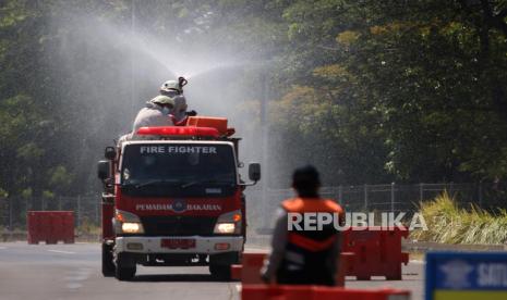 Petugas Dinas Pemadam Kebakaran Kota Surabaya menyemprotkan larutan disinfektan di area pos penyekatan Jembatan Suramadu, Surabaya, Jawa timur, Kamis (10/6/2021). Penyemprotan disinfektan dilakukan di area pos penyekatan yang menjadi tempat dilakukannya tes cepat antigen dan tes usap PCR bagi warga dari Pulau Madura yang menuju maupun melintas ke Surabaya, menyusul meningkatnya kasus COVID-19 di Bangkalan, Madura. 