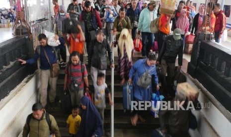 Penumpang kereta api Jayabaru  menuruni tangga pintu keluar di stasiun Kereta api Senen Jakarta, Kamis (21/2).