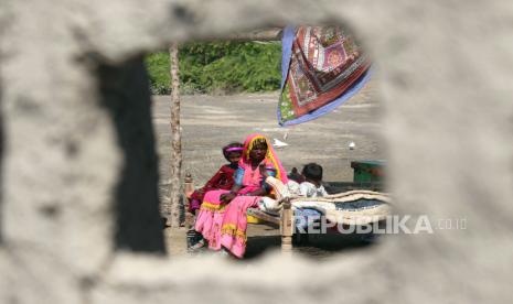  Penduduk setempat menunggu bantuan di daerah yang dilanda banjir di distrik Mirpur Khas, provinsi Sindh, Pakistan, 10 Oktober 2022. Menurut otoritas manajemen bencana, sekitar 160 jembatan dan 5.000 km (3.200 mil) jalan telah hancur atau rusak, 3,5 juta hektar tanaman terpengaruh, dan sekitar 800.000 ternak hilang. Lebih dari 33 juta orang terkena dampak banjir, kata Menteri Perubahan Iklim negara itu Sherry Rehman. 12 Anak Pengungsi Banjir Pakistan Terbakar Hidup-Hidup di Dalam Bus