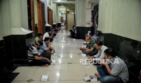 Bolehkah Berbuka Menunggu Gelap Malam? Jamaah menunggu waktu berbuka puasa di Masjid Agung Al-Barkah, Bekasi, Jawa Barat (22/4). Pengurus Masjid Agung Al-Barkah menyediakan sebanyak 300 hingga 500 paket takjil secara gratis untuk jamaah musafir dan warga yang hendak berbuka puasa di masjid dengan tetap menerapkan protokol kesehatan. Republika/Thoudy Badai