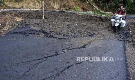 Pengendara melintasi jalan yang amblas (ilustrasi) 