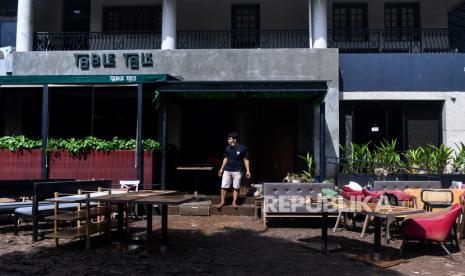 Warga bersiap membersihkan perlengkapan jualan mereka yang terkena banjir di kawasan Kemang, Jakarta Selatan, Minggu (21/2/2021). Banjir yang melanda permukiman warga di kawasan tersebut sudah berangsur surut dan warga mulai membersihkan lumpur sisa banjir. 