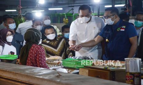 Menteri Perdagangan (Mendag) Muhammad Lutfi (kedua kanan) dan Gubernur Jawa Barat M Ridwan Kamil (kanan) berbincang dengan pedagang saat meninjau harga kebutuhan pokok di Pasar Kosambi, Kota Bandung, Selasa (13/4). Mendag akan melakukan pemantauan terhadap sejumlah komuditas kebutuhan pokok selama Ramadhan agar tetap terjaga stoknya dan stabil hargannya.