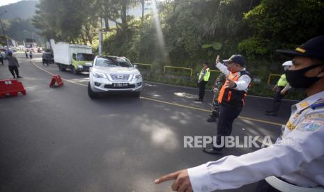 Petugas gabungan memutar balik kendaraan di titik pemeriksaan perbatasan Bogor-Cianjur, Jalan Raya Puncak, Kabupaten Bogor, Jawa Barat, Senin (1/6/2020). Petugas gabungan memperketat akses keluar masuk kendaraan yang melewati perbatasan dalam pemberlakuan Pembatasan Sosial Berskala Besar (PSBB) di Bogor