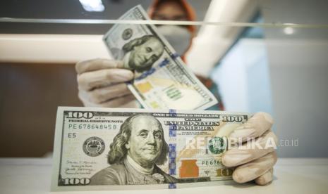 Petugas menghitung uang dolar AS di BNI KC Mega Kuningan, Jakarta, Kamis (21/7/2022). Nilai tukar rupiah terhadap dolar Amerika Serikat (AS) pada penutupan perdagangan hari ini melemah ke level Rp15.036 per USD, seiring dengan langkah kebijakan moneter Bank Indonesia (BI) yang kembali mempertahankan suku bunga acuannya di level 3,50 persen. 