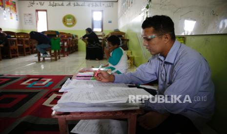  Seorang guru memberikan instruksi kepada siswa sambil mendengarkan protokol kesehatan pada sesi kelas di SD Nurul Amal di Tangerang Selatan, Indonesia, 23 November 2020. Pemerintah pusat memberikan kewenangan penuh kepada pemerintah daerah untuk membuka kembali sekolah dan melaksanakan tatap muka. menghadapi proses pembelajaran yang akan dimulai pada Januari 2021 di tengah pandemi virus corona.