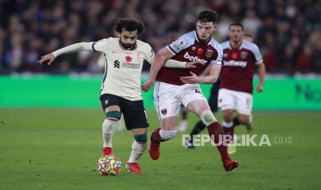 Pemain Liverpool Mohamed Salah, kiri, dan pemain West Ham Declan Rice berebut bola selama pertandingan sepak bola Liga Premier Inggris antara West Ham United dan Liverpool di stadion London di London, Inggris, Minggu, 7 November 2021.