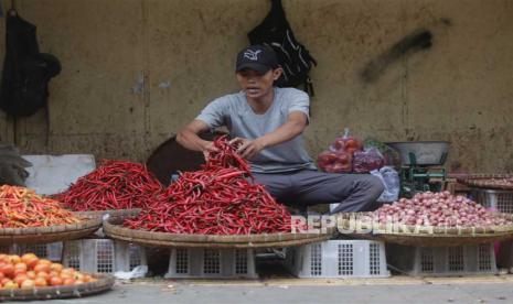  Seorang pedagang menunggu pelanggan saat ia menjual dagangannya di sebuah jalan di Bogor. Tim Pengendalian Inflasi Pusat (TPIP) memastikan akan terus memperkuat sinergi dengan melanjutkan implementa 