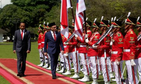 Perdana Menteri baru Malaysia Anwar Ibrahim (Tengah) didampingi oleh Presiden Indonesia Joko Widodo (kiri) saat ia memeriksa pasukan kehormatan saat kedatangannya di Istana Kepresidenan di Bogor, Indonesia, 09 Januari 2023. Selama menjabat presiden, Jokowi telah bertemu lima perdana menteri Negeri Jiran. 