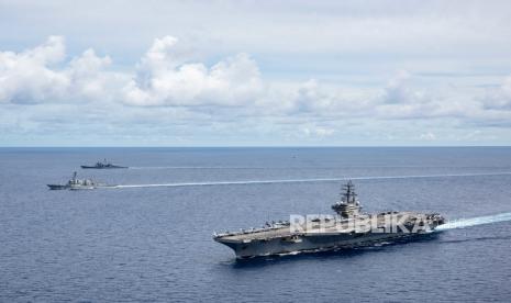 Kapal induk USS Ronald Reagan (CVN 76) (R), kapal perusak rudal berpemandu kelas Arleigh Burke USS Mustin (DDG 89) (L) dan kapal penjelajah rudal berpemandu USS Antietam (CG 54) (2-L) berlayar di formasi selama latihan di Laut Cina Selatan, 06 Juli 2020. Pada 13 Juli 2020, Menteri Luar Negeri AS Mike Pompeo secara resmi menolak sebagian besar klaim China atas Laut Cina Selatan. 