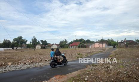 Warga berspeda motor di lokasi titik awal pembangunan Jalan Tol Yogyakarta-Bawen di Tirtoadi, Sleman, Yogyakarta, Kamis (7/4/2022). Warga mulai membongkar rumah secara mandiri di dekat lokasi groundbreaking Jalan Tol Yogyakarta-Bawen. Rencannya Kementerian Pekerjaan Umum dan Perumahan Rakyat (PUPR) memulai pembangunan Jalan Tol Yogyakarta- Bawen pada akhir Maret 2022.