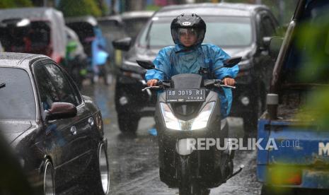 Pengendara menggunakan ponco saat hujan (ilustrasi)