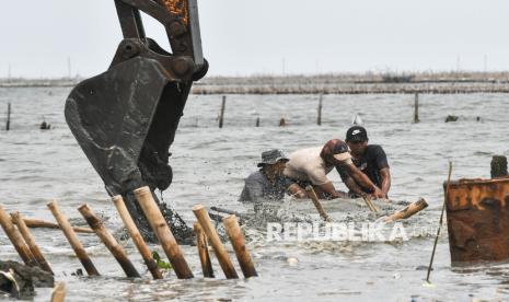 Sejumlah pekerja dari PT TRPN membongkar bambu menggunakan alat berat escavator di pesisir laut Tarumajaya, Kabupaten Bekasi, Jawa Barat, Selasa (11/2/2025). Kementerian Kelautan dan Perikanan (KKP) menyatakan pembongkaran pagar laut sepanjang 3,3 Km dilakukan secara mandiri oleh PT TRPN  yang merupakan bagian dari tindak lanjut sanksi administratif atas pelanggaran pemanfaatan ruang laut dan reklamasi tanpa izin. 