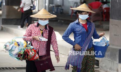  Vendor menjual makanan ringan dan air minum di terminal bus jalan raya di Yangon, Myanmar, 20 Desember 2020. 