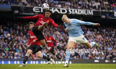 Raphael Varane dari Manchester United (kiri) dan Erling Haaland dari Manchester City berebut bola saat pertandingan sepak bola Liga Premier Inggris antara Manchester City dan Manchester United di Stadion Etihad di Manchester, Inggris,  Ahad (3/3/2024).