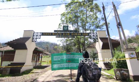 Warga melihat pengumuman yang dipasang di depan pintu masuk Taman Wisata Alam (TWA) Kawah Ijen, Banyuwangi, Jawa Timur, Jumat (10/4). (ilustrasi)