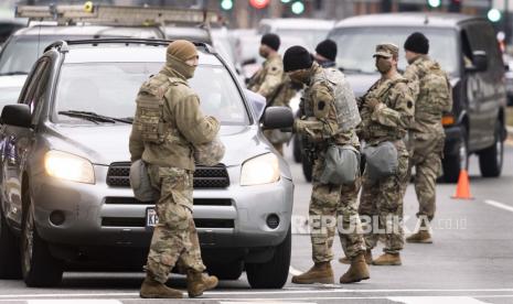 Pasukan Pengawal Nasional Bersenjata dari Pennsylvania membantu menjalankan pos pemeriksaan di Massachusetts Avenue untuk membantu mengamankan jalan-jalan menuju gedung Capitol AS di Washington, DC, AS, 15 Januari 2021. Setidaknya dua puluh ribu tentara Pengawal Nasional dan tindakan keamanan lainnya sedang dikerahkan di Washington untuk membantu mengamankan daerah Capitol sebagai tanggapan atas potensi kerusuhan yang terjadi di sekitar pelantikan Presiden terpilih AS Joe Biden minggu depan.