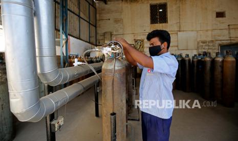  Seorang pekerja menyiapkan tabung oksigen kosong untuk diisi di pusat pengisian oksigen di tengah gelombang ketiga peringatan Omicorn varian Sars-CoV-2 baru, di Bangalore, India, 11 Januari 2022. India mencatat 8.21.446 infeksi COVID-19 dan 277 kematian dalam 24 jam terakhir.