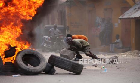  Orang-orang mengambil bagian dalam hari protes yang terjadi pada saat yang sama ketika orang-orang Haiti memberikan penghormatan kepada presiden yang dibunuh Jovenel Moise, di Cap-Haitien, Haiti, 22 Juli 2021. Para pengunjuk rasa yang menuntut keadilan bagi Moise mendirikan api unggun dan barikade di berbagai titik di kota, di utara negara itu, tempat presiden dilahirkan. Sejauh ini, 26 orang telah ditangkap karena diduga terlibat dalam pembunuhan tersebut.