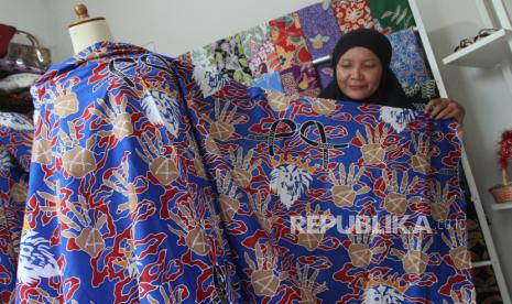 Pembatik Ita Fitriyah menunjukkan kain batik tulis bermotif tragedi Kanjuruhan buatannya di rumah produksi Batik Lintang, Karangploso, Malang, Jawa Timur, Senin (9/1/2023). Kain batik yang hanya dibuat dua lembar tersebut dilelang di media sosial untuk donasi bagi korban tragedi Kanjuruhan. 