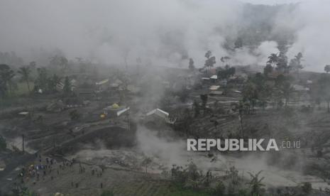  Foto udara yang diambil dengan drone ini menunjukkan tim penyelamat sedang memeriksa kerusakan di sebuah desa yang terkena dampak letusan Gunung Semeru di Sumberwuluh, Lumajang, Jawa Timur, Indonesia, Senin, 5 Desember 2022. Kondisi cuaca yang membaik pada Senin memungkinkan tim penyelamat melanjutkan upaya evakuasi dan pencarian korban setelah gunung berapi tertinggi di pulau terpadat di Indonesia meletus, dipicu oleh hujan monsun.