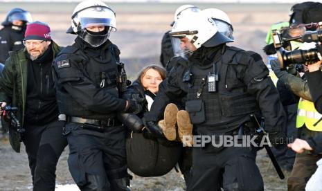  Petugas polisi membawa aktivis iklim Swedia Greta Thunberg menjauh dari tepi tambang lignit terbuka Garzweiler II selama aksi protes oleh aktivis iklim setelah pembersihan Luetzerath, Jerman, Selasa (17/1/2023).Setelah penggusuran Luetzerath berakhir pada Ahad , penentang batu bara melanjutkan protes mereka pada hari Selasa di beberapa lokasi di Rhine-Westphalia Utara.