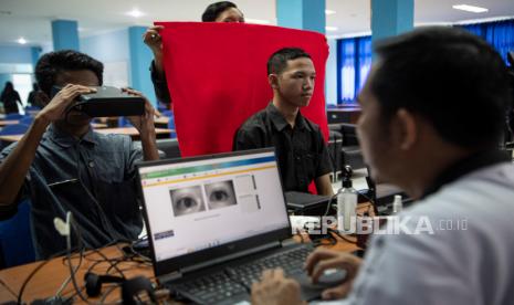 Petugas melakukan perekaman data biometrik mata saat pembuatan KTP elektronik bagi siswa di SMK Negeri 2 Palembang, Sumatera Selatan, Kamis (3/11/2022). Dinas Kependudukan dan Catatan Sipil (Disdukcapil) Kota Palembang melakukan perekaman KTP elektronik bagi siswa SMK dan sederajat dengan mendatangi langsung sejumlah sekolah untuk mempercepat dan memudahkan siswa yang telah berusia 17 tahun mendapatkan KTP elektronik. 