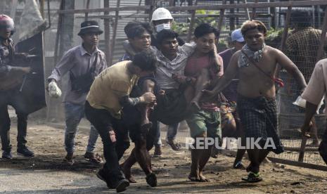  Para pengunjuk rasa membawa seorang demonstran yang terluka selama protes melawan kudeta militer di Kotapraja Hlaingthaya (Hlaing Tharyar), pinggiran Yangon, Myanmar,  Ahad (14/3). Protes antikudeta terus berlanjut meskipun penumpasan kekerasan yang intensif terhadap demonstran oleh pasukan keamanan.