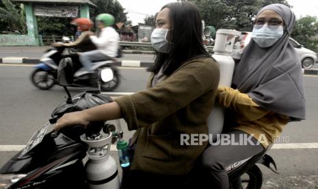 Pembeli membawa tabung oksigen setelah isi ulang di Radix Gas Medical, Cibinong, Kabupaten Bogor, Jawa Barat.